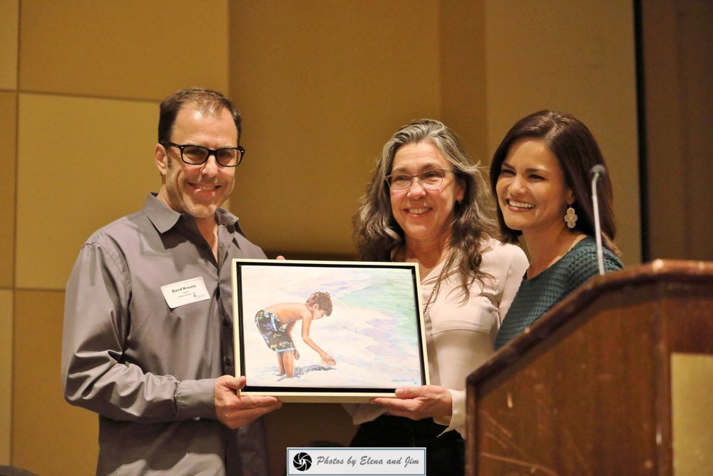 Two women and one man showing painting