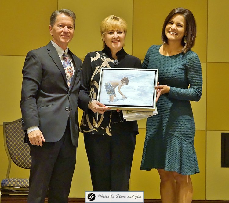 Two women and one man showing paiting