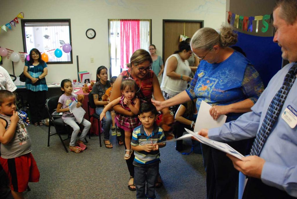 Man giving certificates to little children's