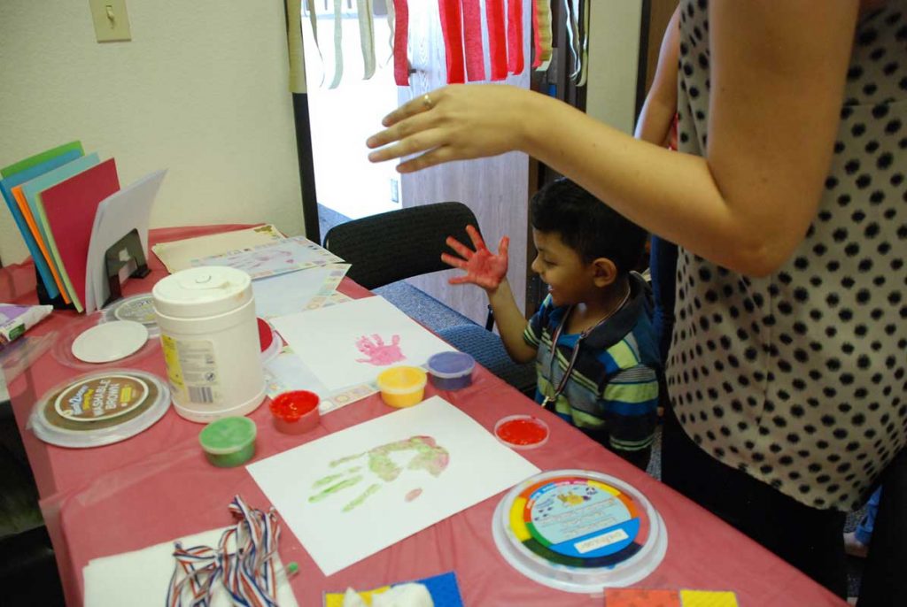 Little boy painting with hand