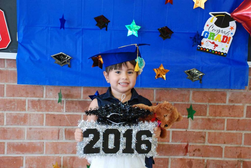 Little girl holding 2016 banner sign