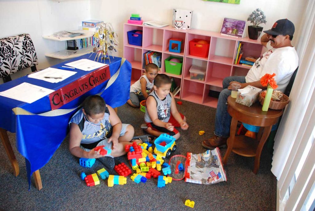 Man with three little children's playing with toys