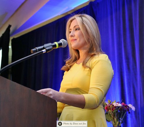 Women in a yellow dress speaking on a mic