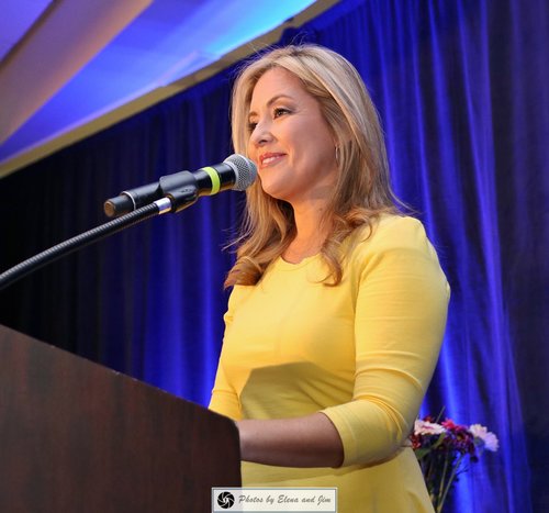 Women in a yellow dress speaking on a mic