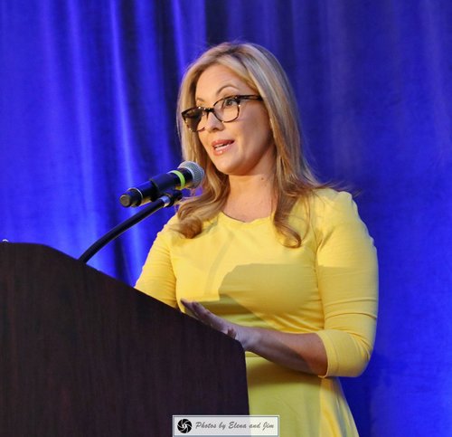 Women in a yellow dress speaking on a mic