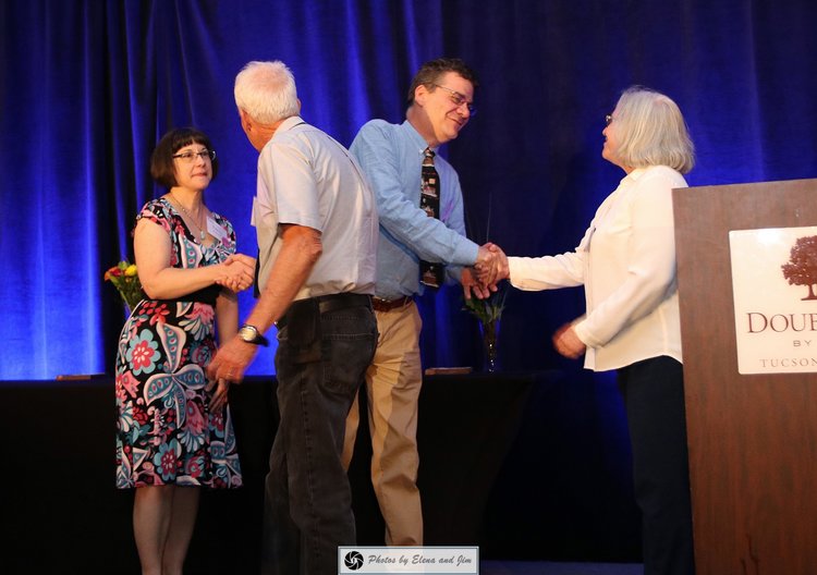 Man and women shaking hands on a stage