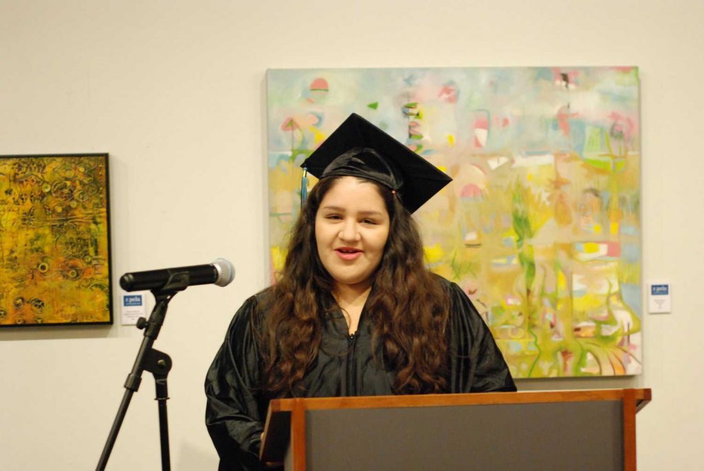 Women with graduation cap speaking on mic