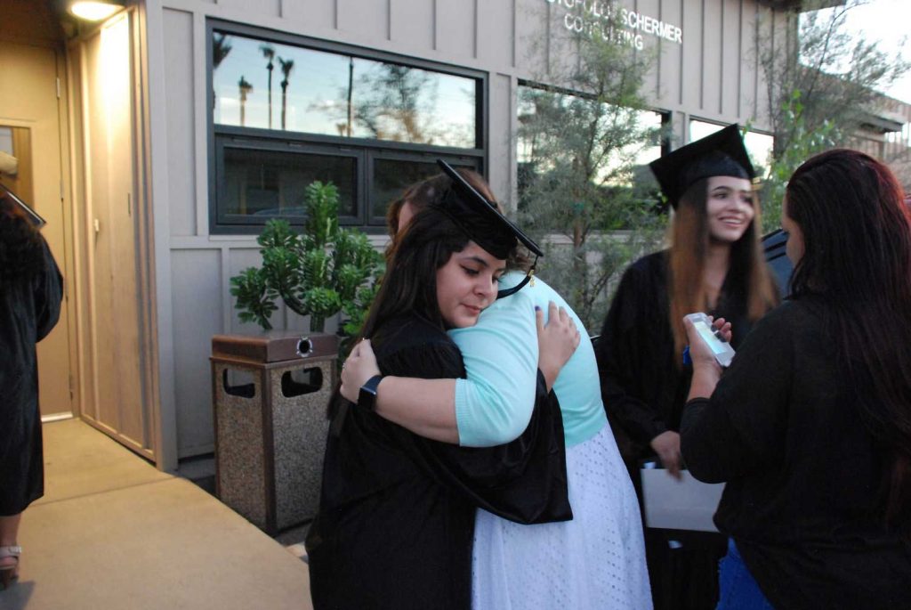 Women hugging students