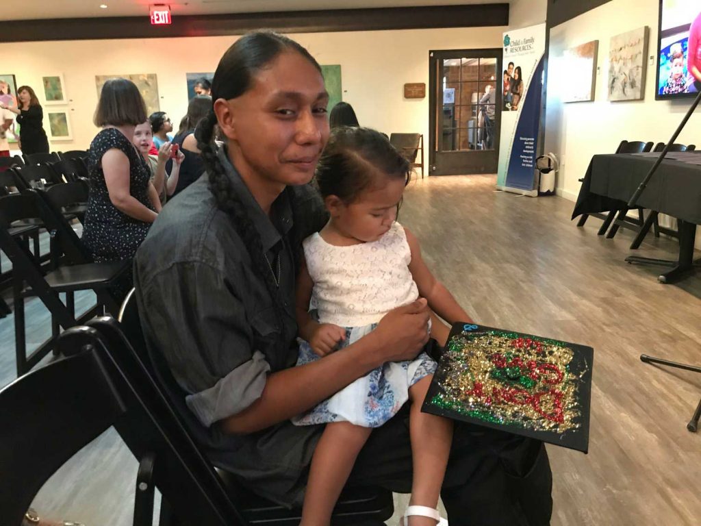 Mother holding her daughter with painting