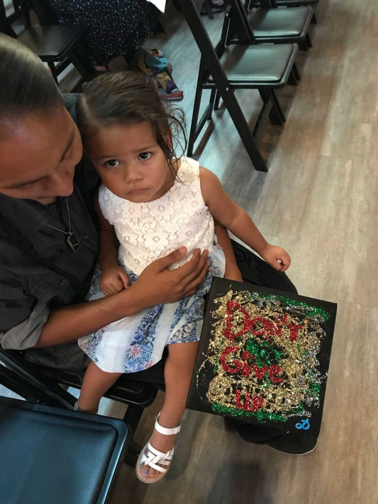 Mother holding her daughter with painting