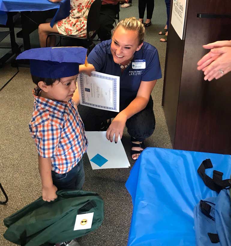 Team member giving certificate to little boy