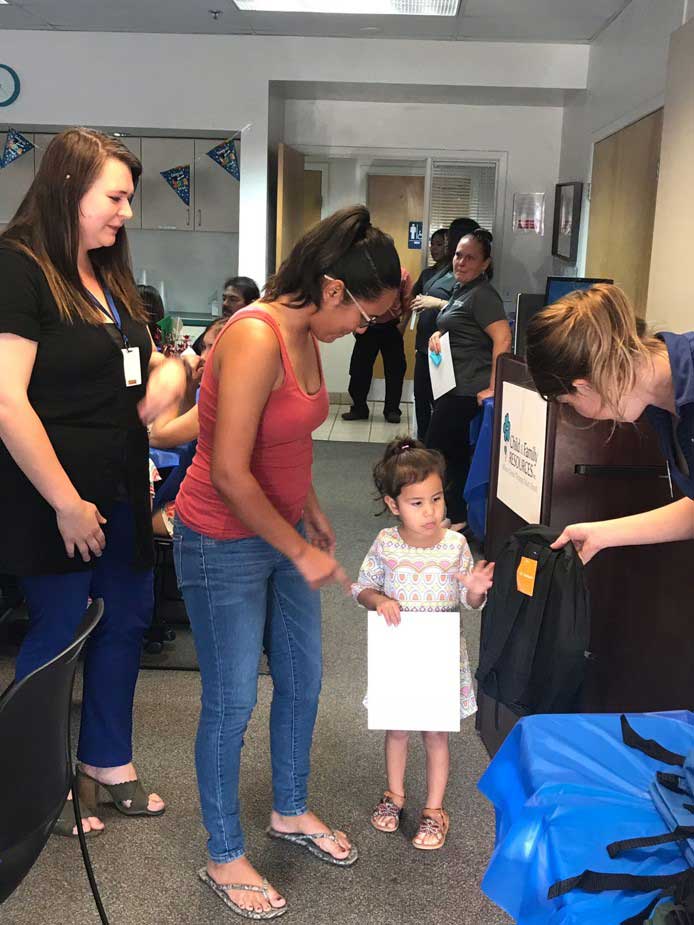 Team member giving bag to little girl