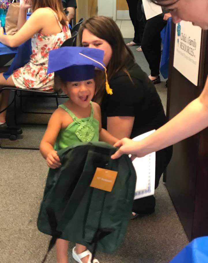 Team member giving bag to little girl