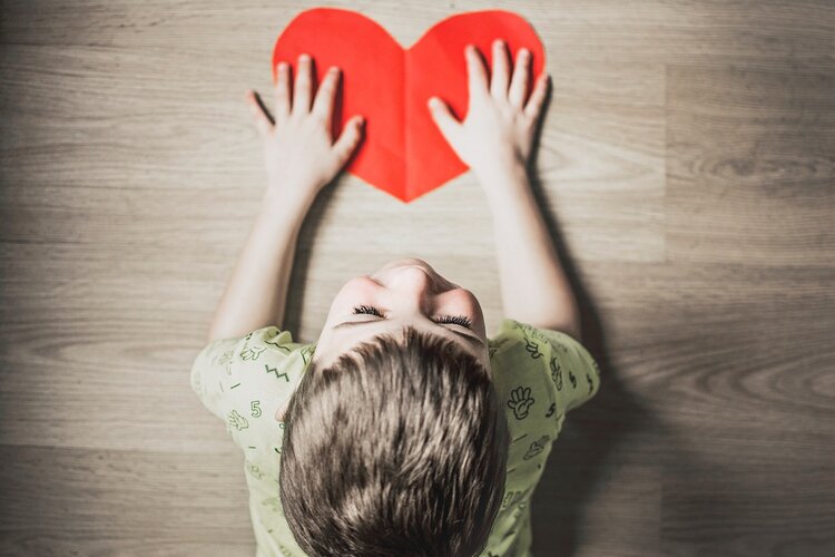 Kid playing with heart shape card