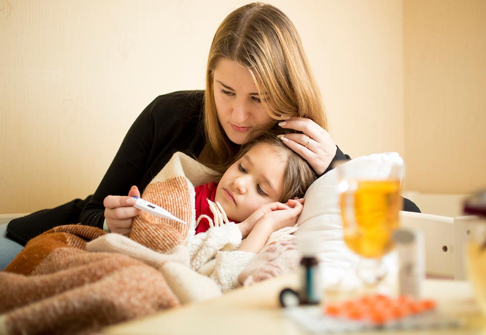 Mother checking the temperature of her daughter