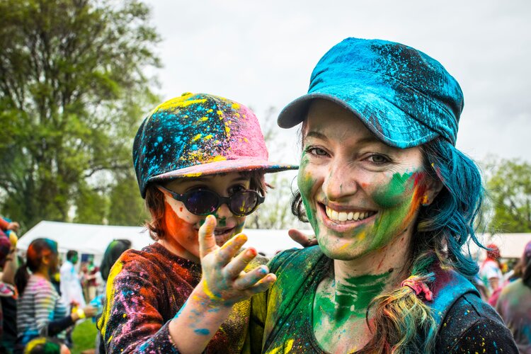 Happy mom and son in colorful mood at festival