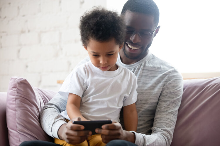 Smiling father and daughter using phone