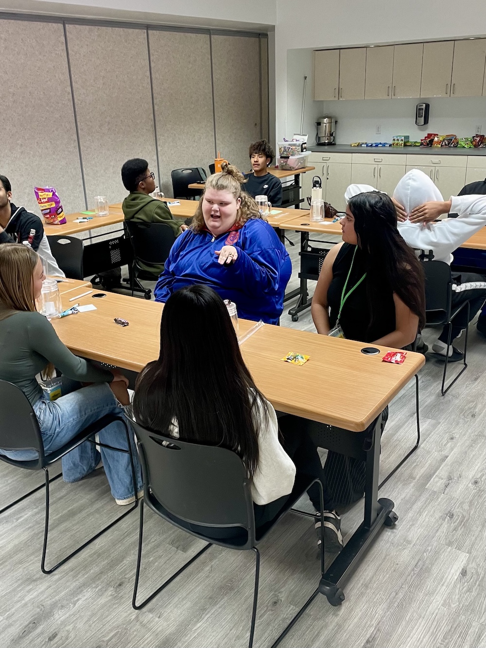 Teens seated around tables having a discussion at Child & Family Resources
