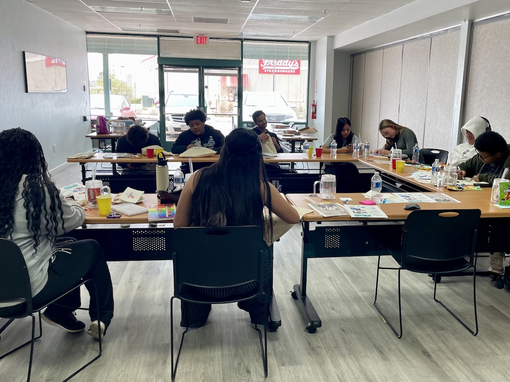 Youth workshop around U-shaped tables with art supplies