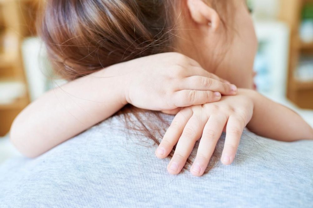 Child hugging caregiver in comforting embrace