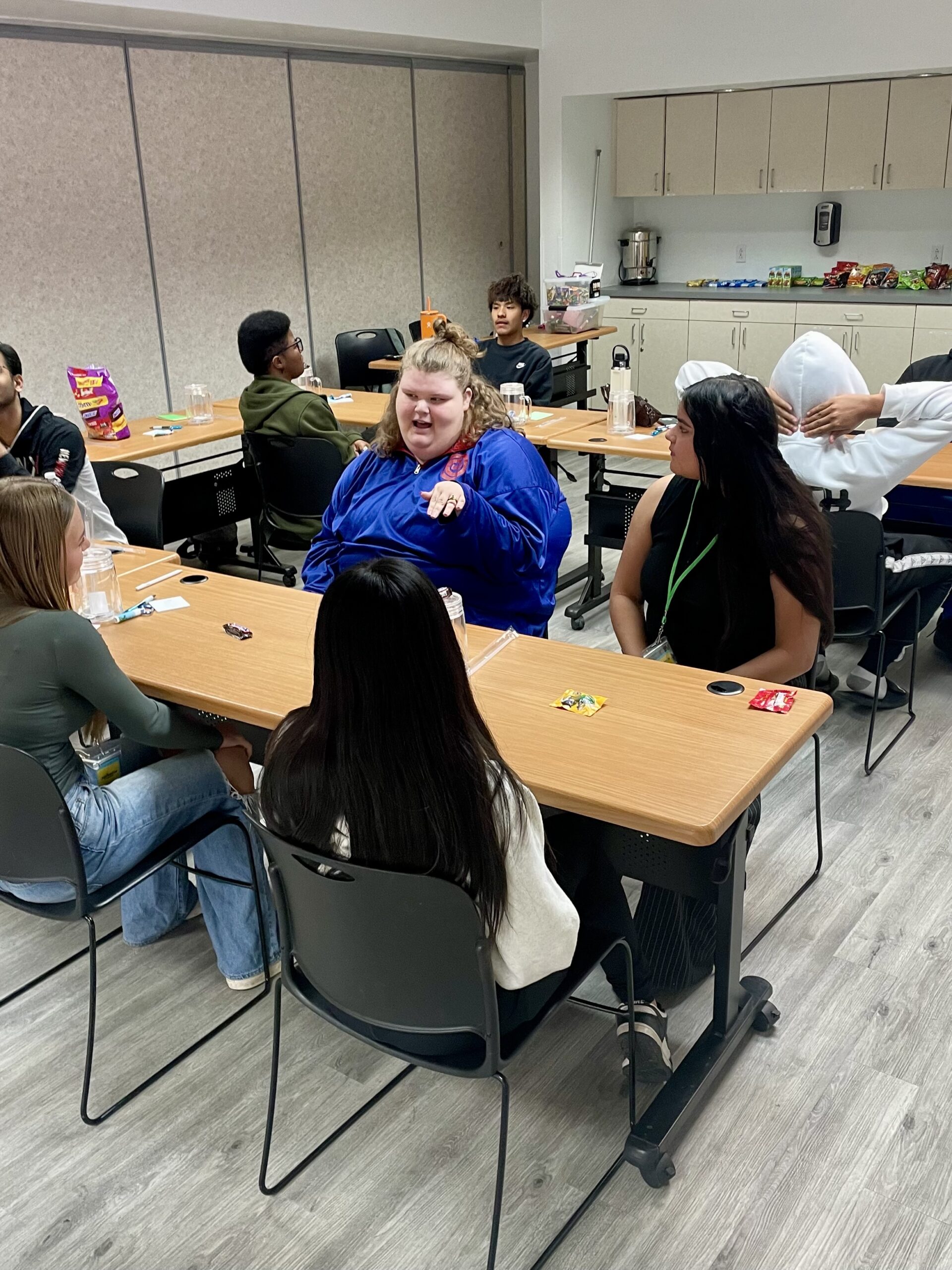 Teens seated around tables having a discussion at Child & Family Resources