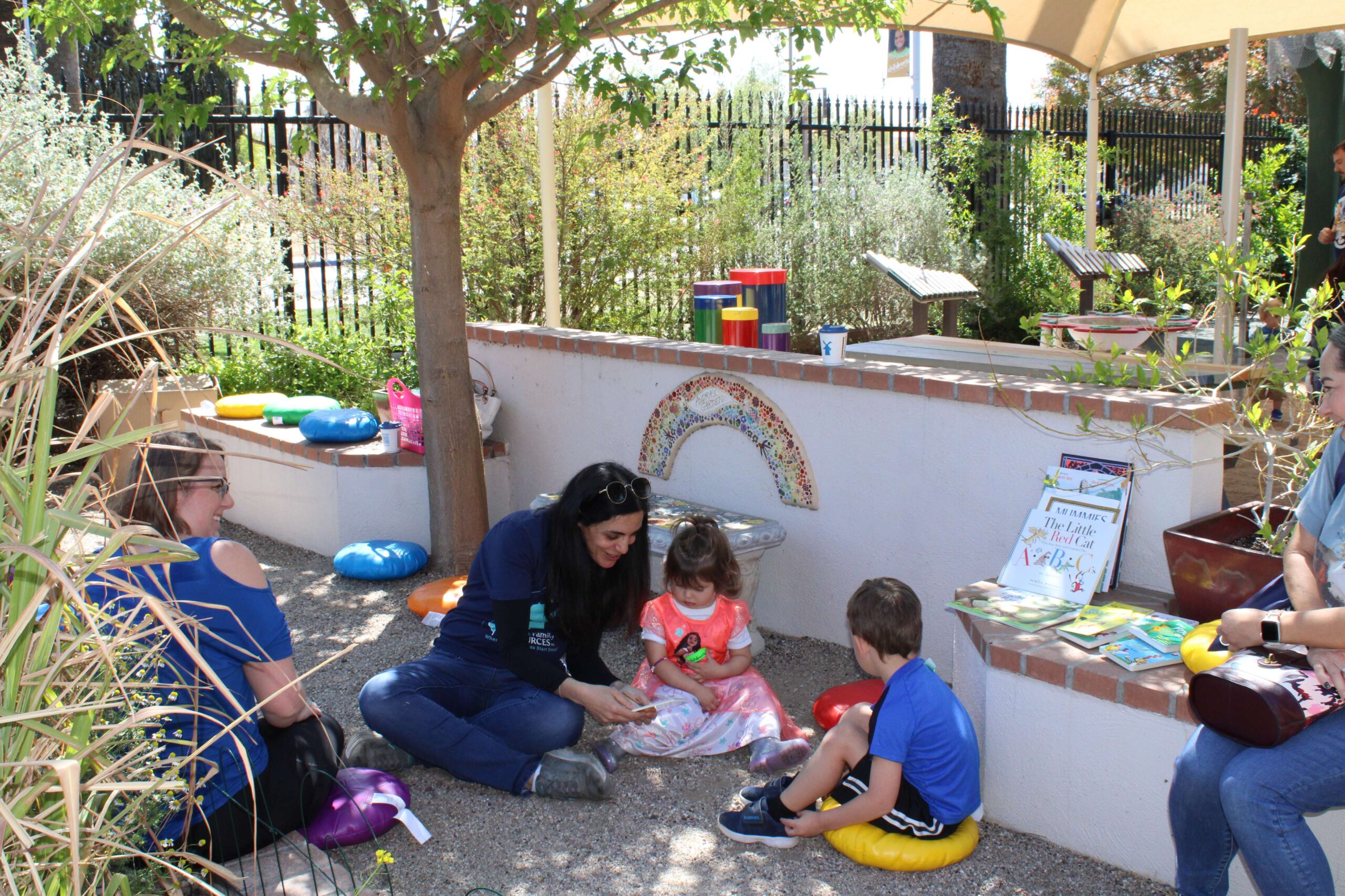 Team member reads to two children outdoors