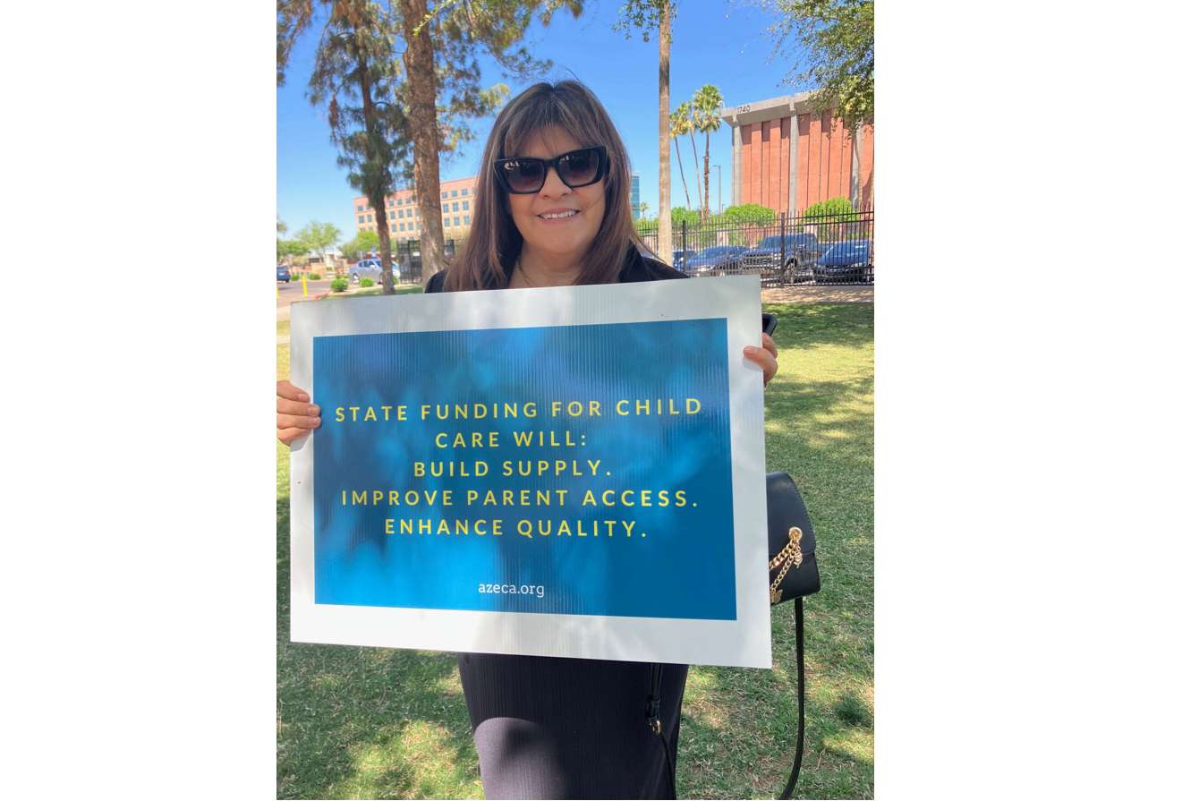 Woman holds sign that says: STATE FUNDING FOR CHILD CARE WILL: BUILD SUPPLY. IMPROVE PARENT ACCESS. ENHANCE QUALITY. azeca.org